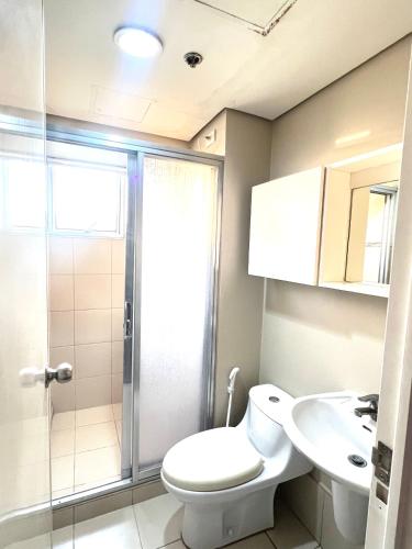a bathroom with a shower and a toilet and a sink at Huge 2BR Condo in IT Park Cebu in Cebu City
