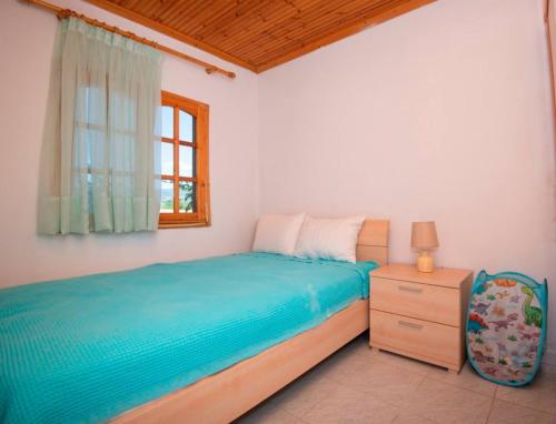 a bedroom with a bed and a dresser and a window at Casa Chrysi in Mesimvría