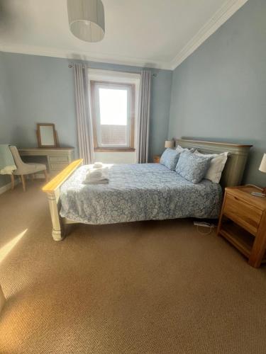 a bedroom with a bed and a window at Coastal Retreat in Fife