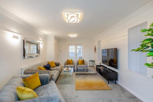 a living room with a couch and a tv at Robinswood House in Gloucester