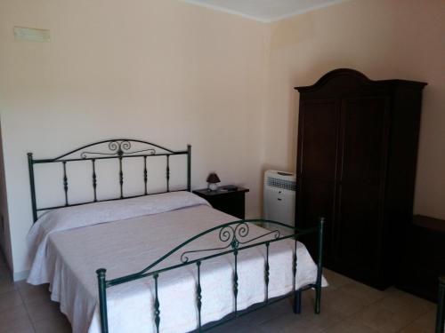 a bedroom with a bed and a wooden dresser at La Mortella Agriturismo in Rotondella
