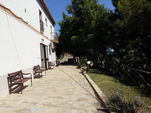 two benches sitting on a sidewalk next to a building at La Mortella Agriturismo in Rotondella