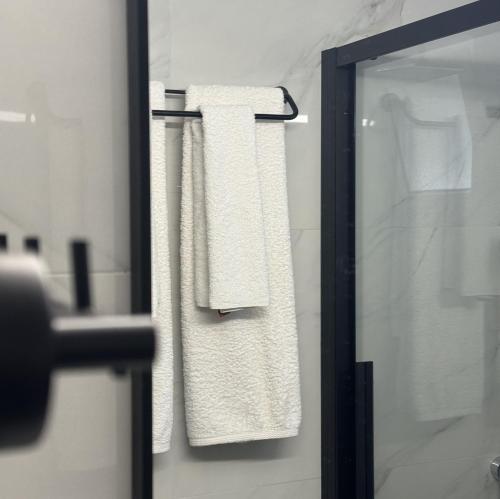a bathroom with white towels on a towel rack at Vasilios Marinos Rooms in Korinthos