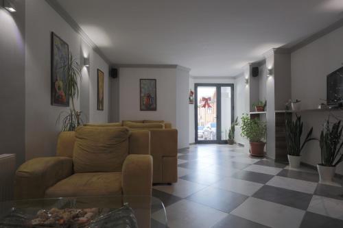 a living room with a couch and a tile floor at Hotel Denis in Pristina