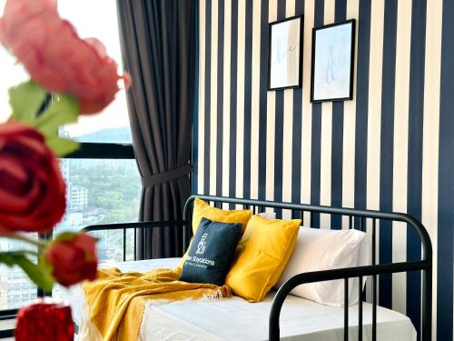 a bed with yellow and blue pillows in a room at New Urban Suite Majestics 3BR Homestay at Georgetown BY URBAN STAYCATION HENG LOD in Jelutong
