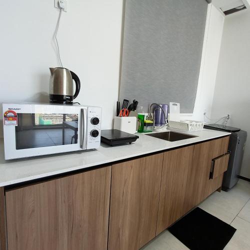 a kitchen counter with a microwave and a sink at New Urban Suite Majestics 3BR Homestay at Georgetown BY URBAN STAYCATION HENG LOD in Jelutong