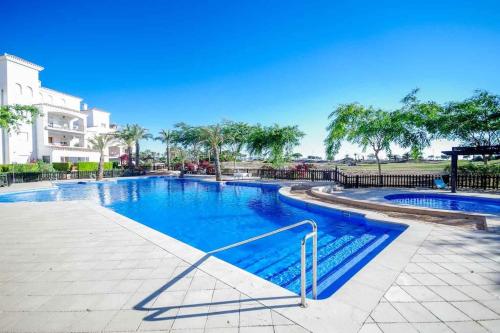 - une grande piscine d'eau bleue dans un complexe dans l'établissement Rez-de-chaussée bord de piscine, à Los Tomases