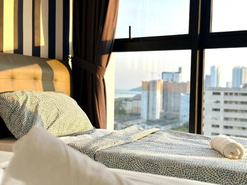 a bed with a window with a view of a city at New Urban Suite Majestics 3BR Homestay at Georgetown BY URBAN STAYCATION HENG LOD in Jelutong