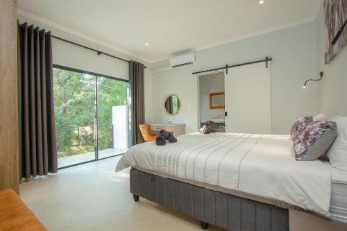 a bedroom with a large bed and a large window at Maroela Safari House in Marloth Park