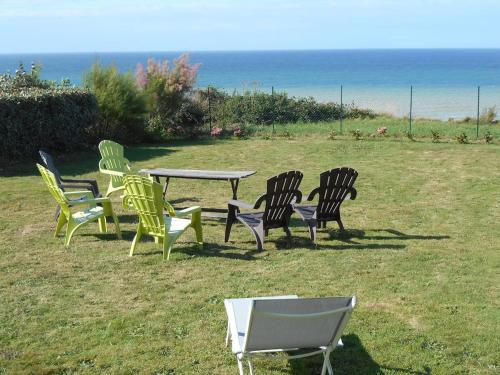 a group of chairs and a table in a field at VILLA LES MOUETTES - Maison 8 couchages in Quiberville