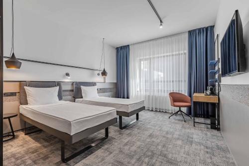 a hotel room with two beds and a chair at IQ Hotel in Kyiv