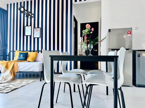 a dining room with a black table and white chairs at New Urban Suite Majestics 3BR Homestay at Georgetown BY URBAN STAYCATION HENG LOD in Jelutong