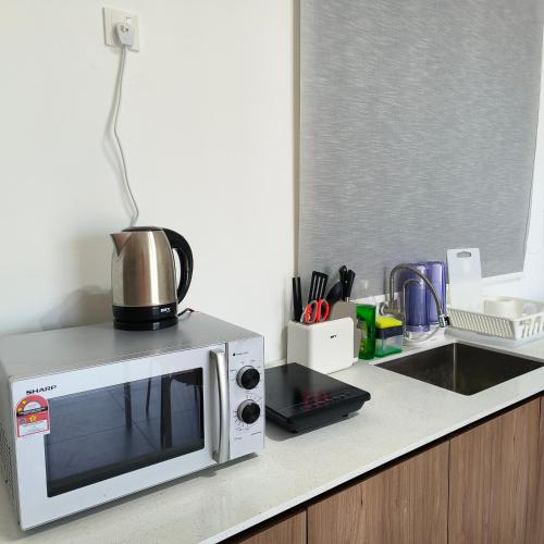 a microwave sitting on a counter in a kitchen at New Urban Suite Majestics 3BR Homestay at Georgetown BY URBAN STAYCATION HENG LOD in Jelutong