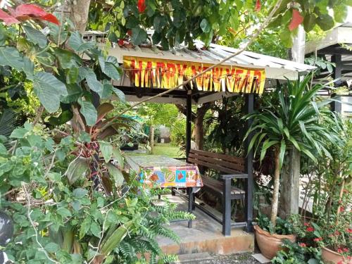 a table and a bench in a garden at Wattana Bungalow in Nai Yang Beach