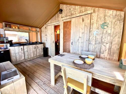 cocina con mesa de madera en una habitación en DOMAINE DU CHENE en Campagnan