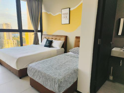 two beds in a hotel room with a window at New Urban Suite Majestics 3BR Homestay at Georgetown BY URBAN STAYCATION HENG LOD in Jelutong