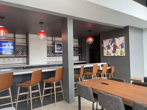 a bar with chairs and a table in a restaurant at Atwell Suites Austin Airport, an IHG Hotel in Austin