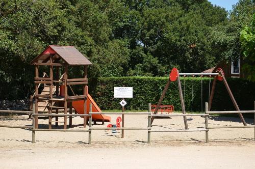 une aire de jeux avec un toboggan et une balançoire dans l'établissement Camping Le Roc, à Rocamadour