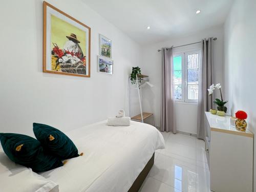 une chambre blanche avec un grand lit avec des oreillers verts dans l'établissement Tivoli 4 - Renovated 2 bedrooms appartment, Monaco Border, 5mn from Casino Monte Carlo, à Beausoleil