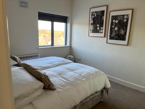 1 dormitorio con 1 cama blanca y ventana en 2 Bedroom apartment Park Lodge en Enniscorthy