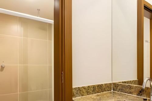 La salle de bains est pourvue d'une douche et d'un miroir. dans l'établissement Ondas Praia Resort em Porto Seguro, à Porto Seguro