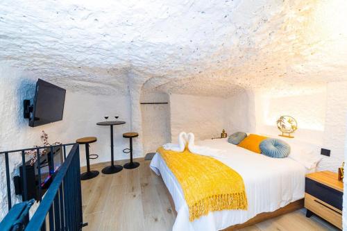 a bedroom with a bed and a tv on the wall at ALOJAMIENTOS EL FARO DEL JÚCAR in Alcalá del Júcar