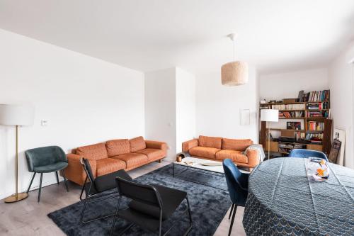 sala de estar con sofá, mesa y sillas en Bright T5 with terrace in Saint-Ouen - Welkeys, en Saint-Ouen