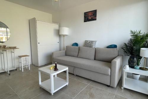 un salon avec un canapé et deux tables dans l'établissement Studio avec terrasse vue mer proche centre ville, à Sainte-Maxime
