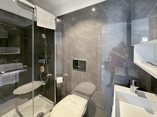 une salle de bain avec toilettes et douche en verre dans l'établissement Tivoli 4 - Renovated 2 bedrooms appartment, Monaco Border, 5mn from Casino Monte Carlo, à Beausoleil