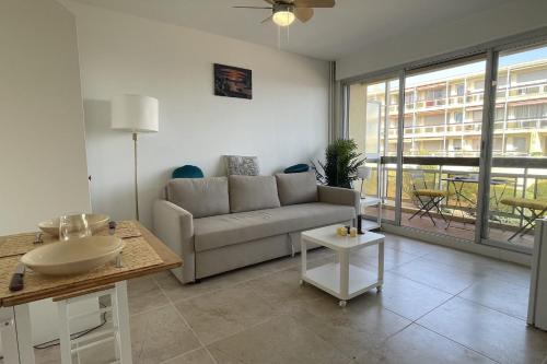 un salon avec un canapé et une table dans l'établissement Studio avec terrasse vue mer proche centre ville, à Sainte-Maxime