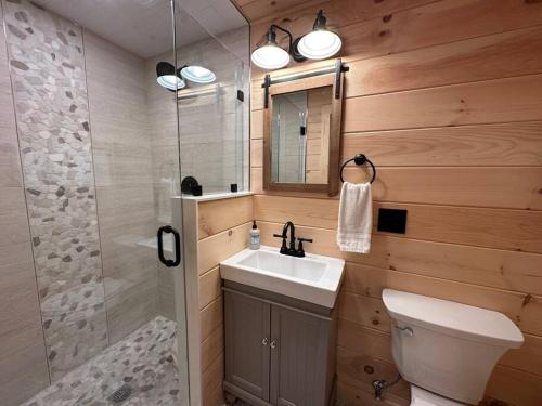 Un baño con inodoro, lavabo y ducha. en Redwood - Lakeside Cabin, en Bradford