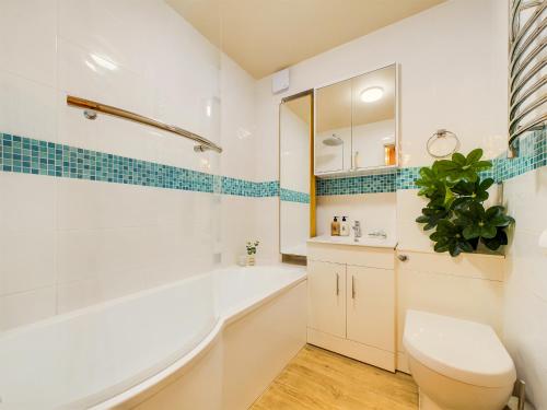 a bathroom with a tub and a toilet and a sink at Be London - Covent Garden Residences in London