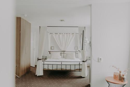 1 dormitorio con 1 cama blanca con dosel en Ouwe Schuure, en Sluis
