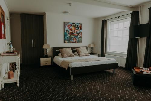 a bedroom with a bed and a window at Ouwe Schuure in Sluis