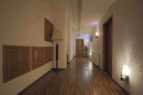 an empty hallway of a building with wood floors and a lamp at Hotel Denis in Pristina