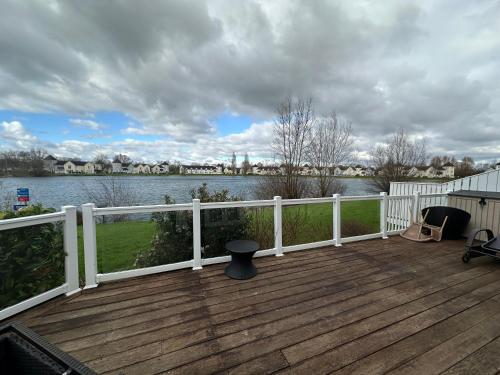 a wooden deck with a view of a body of water at Windrush new house in South Cerney