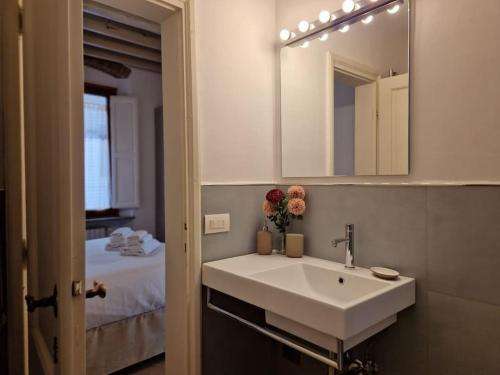 baño con lavabo, espejo y cama en Angolo al Giardino delle Rose, en Florencia
