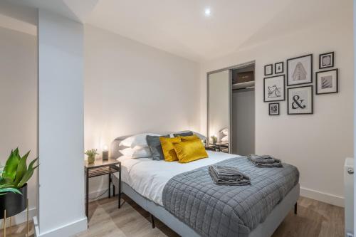 Dormitorio blanco con cama con almohadas amarillas en Fabulous, Modern Apartment, Solihull en Olton