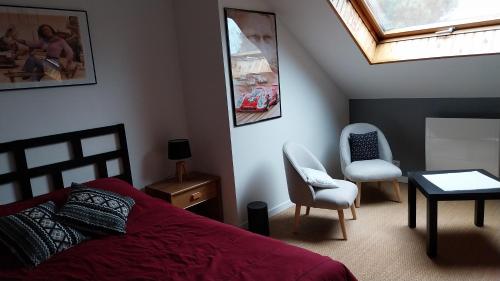 Ruaudin的住宿－Chambres d'hôtes pour 24 heures du Mans , Le Mans classic , Grand prix，卧室配有一张床和一张桌子及椅子