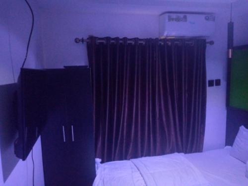um quarto com uma cama e uma janela com cortinas em light house hotel lekki phase 1 em Lekki