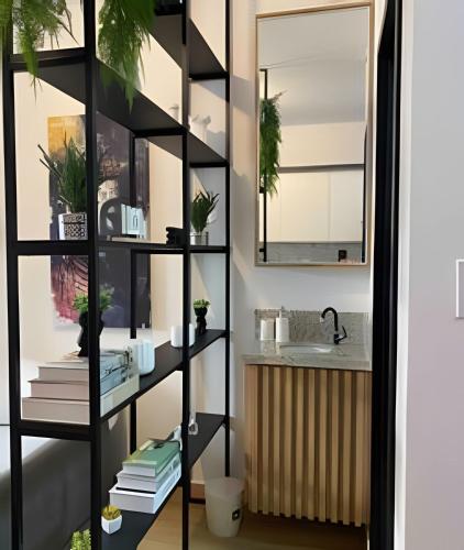 a book shelf with books and a sink in a bathroom at Studio Vila Prudente - Metrô linha verde in São Paulo