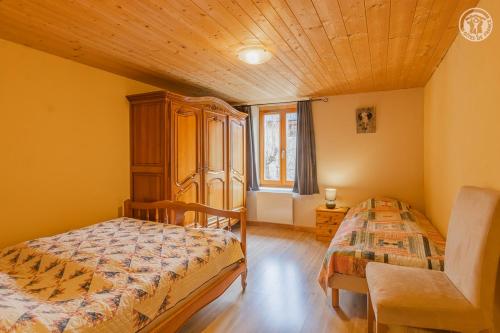 オッソワにあるGîte Le Penatsotの木製の天井が特徴のベッドルーム1室(ベッド2台付)