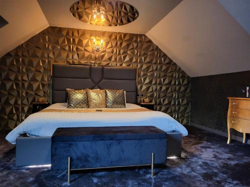 a bedroom with a king sized bed with a large headboard at La Suite de l'Elixir in Argentré-du-Plessis