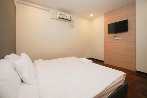 a hotel room with a white bed and a television at โกอินน์ สีลม - สถานีรถไฟฟ้าเซนต์หลุยส์ GO INN Silom - BTS Saint Louis in Yan Nawa
