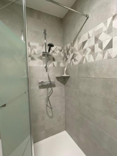 a shower with a glass door in a bathroom at Studio meublé 26m² refait à neuf in Bagnoles de l'Orne