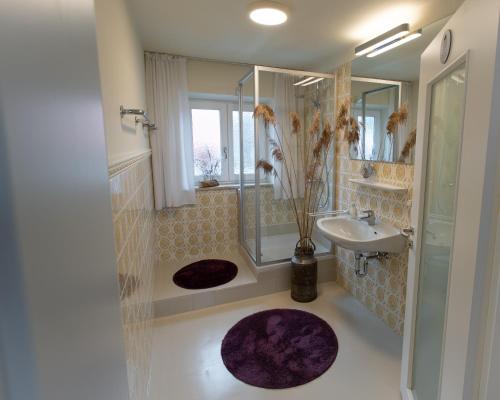 a bathroom with a shower and a sink and a mirror at Gästehaus Nigglhof in Rimsting