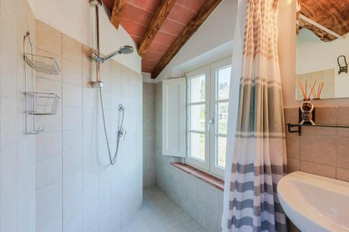 a bathroom with a tub shower and a window at Casa Noscali al Borghetto in Collodi