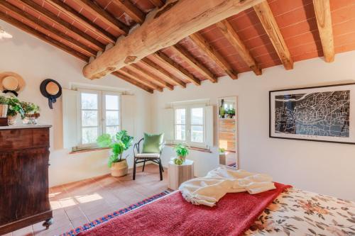 a bedroom with a bed and a chair in a room at Casa Noscali al Borghetto in Collodi