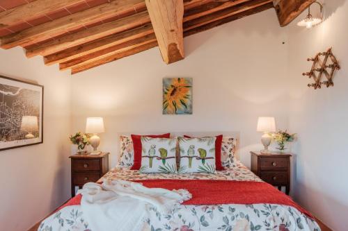 a bedroom with a large bed with red pillows at Casa Noscali al Borghetto in Collodi