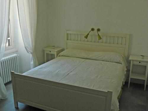 a bedroom with a bed and two tables and a window at B&b Il Sampietrino Dei Cavalleggeri in Rome